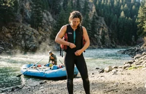 What to Wear Rafting When the Water’s Colder Than the Air Rafter at the put-in dressed for cold water in a wetsuit before a shoulder-season whitewater run