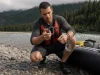 Best River Rescue Carabiners and Pulleys Guides Trust Boater checking river rescue carabiners and pulleys clipped to a raft frame on a gray cobble bar