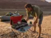 Best Camp Stoves for River Trips That Survive a Flip Two-burner camp stove set up on a river beach kitchen table in Grand Canyon at sunrise