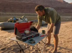 Best Camp Stoves for River Trips That Survive a Flip Two-burner camp stove set up on a river beach kitchen table in Grand Canyon at sunrise