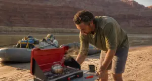 Best Camp Stoves for River Trips That Survive a Flip Two-burner camp stove set up on a river beach kitchen table in Grand Canyon at sunrise