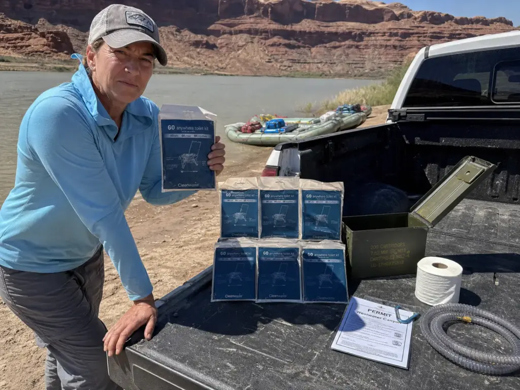Wag bag kits and a steel groover can laid out on a tailgate for a river permit gear check