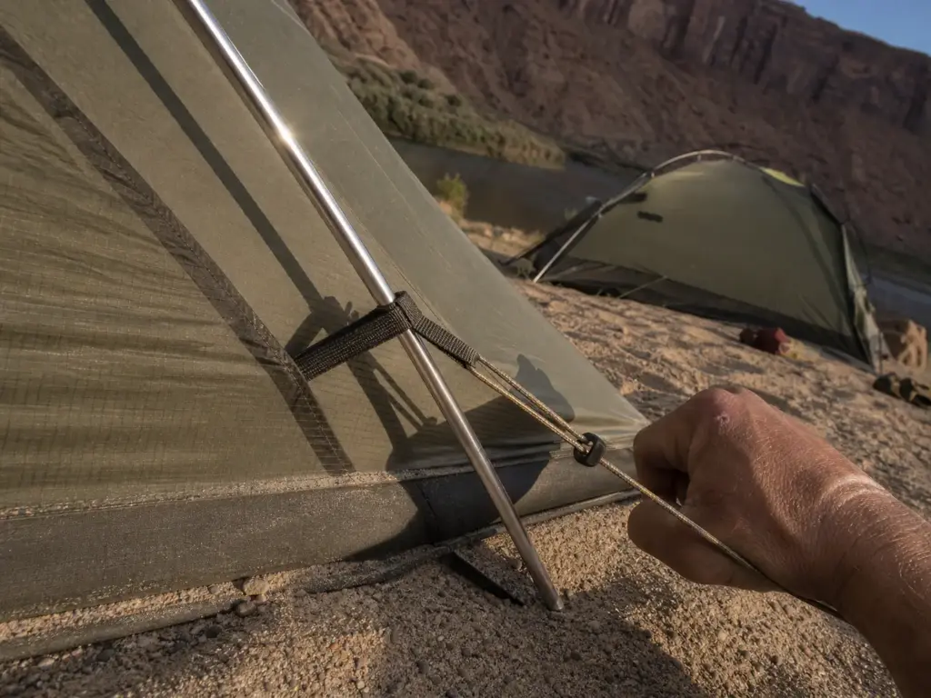 Close look at aluminum tent poles and guy-out points on a freestanding river camping tent