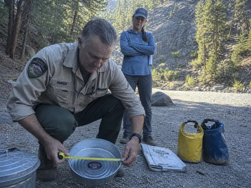 River ranger measuring a galvanized fire pan at a Middle Fork Salmon put-in inspection