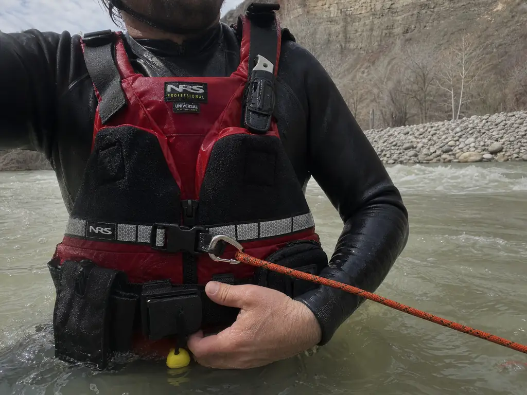 Rescuer's hand on the quick-release buckle of an NRS Rapid Rescuer rescue PFD belt