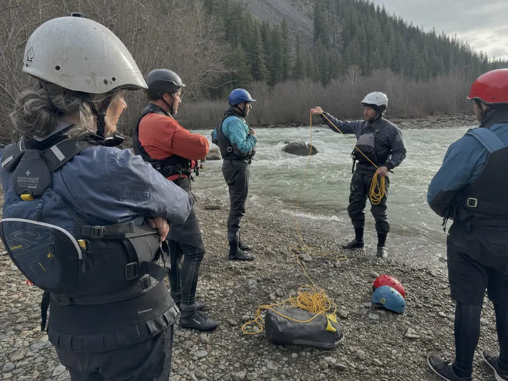 Swiftwater rescue class practicing a line drill on a gravel bar in Type V rescue PFDs