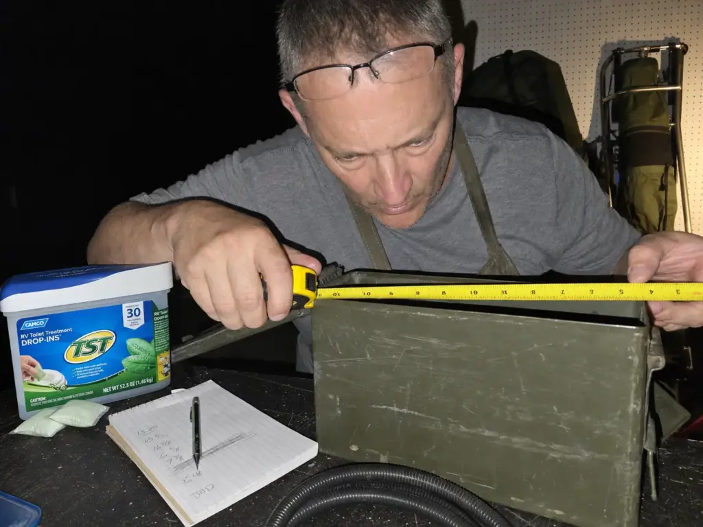 Measuring the inside of a steel ammo can with a tape measure to calculate groover capacity