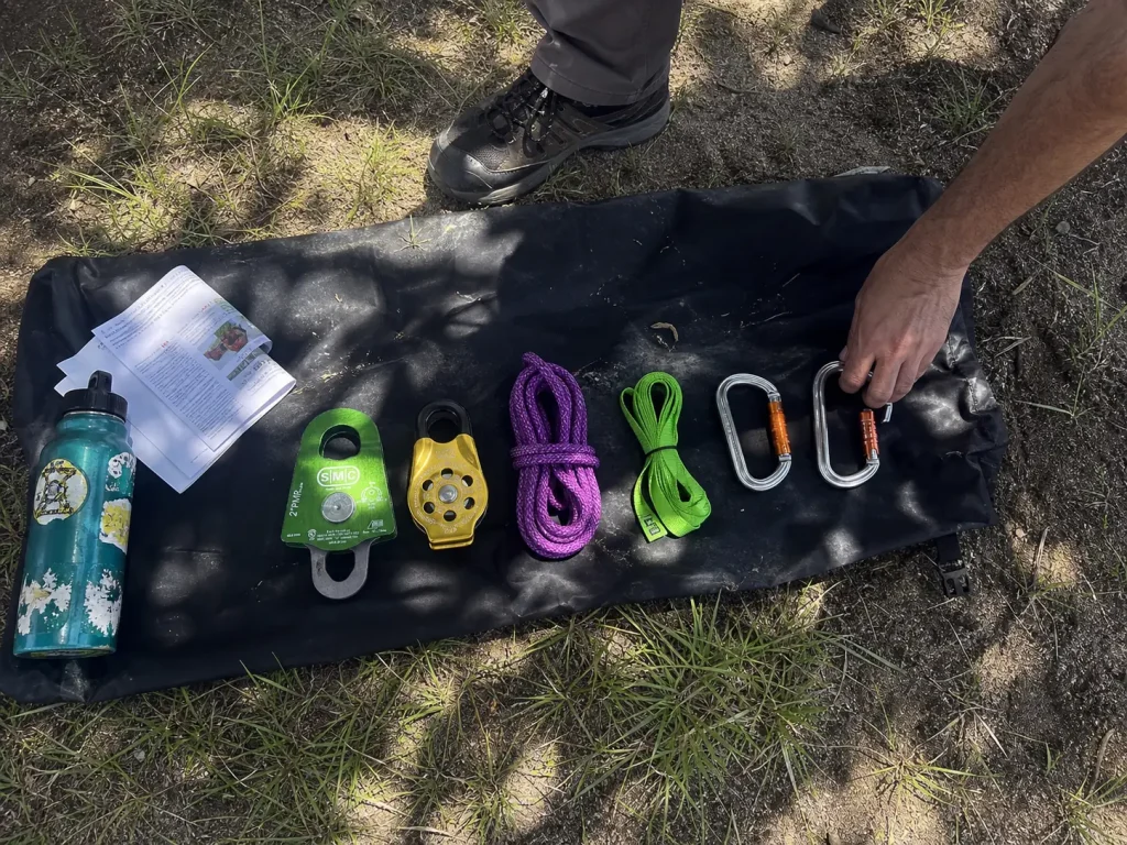 A minimal river rescue kit of two locking carabiners and two pulleys spread on a dry bag